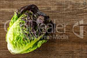 Fresh raw lettuce red little gem on brown wood