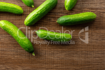 Fresh raw mini cucumber on brown wood