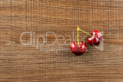 Fresh raw sweet red cherry on brown wood