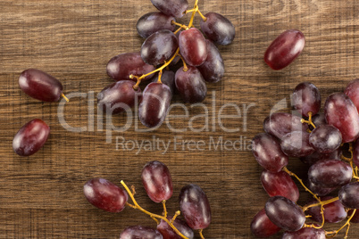 Raw fresh red globe grape on brown wood