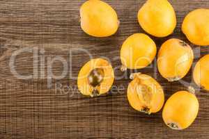 Fresh raw orange japanese loquat on brown wood