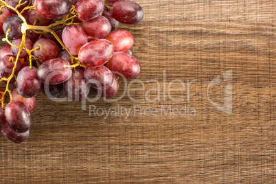 Raw fresh red globe grape on brown wood