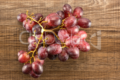 Raw fresh red globe grape on brown wood