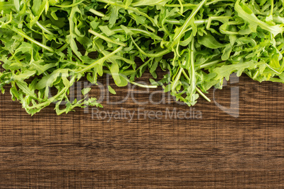 Fresh Raw Arugula (rucola) on brown wood