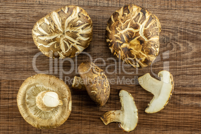 Fresh raw shitake mushroom on brown wood