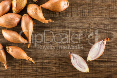 Fresh raw long shallot onion on brown wood