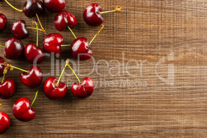 Fresh raw sweet red cherry on brown wood