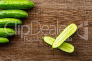 Fresh raw mini cucumber on brown wood