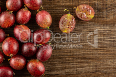 Fresh raw red gooseberry on brown wood