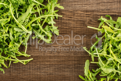 Fresh Raw Arugula (rucola) on brown wood