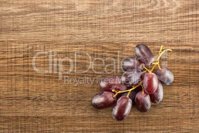 Raw fresh red globe grape on brown wood