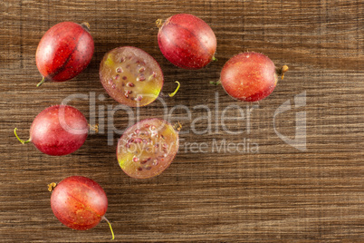 Fresh raw red gooseberry on brown wood