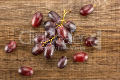 Raw fresh red globe grape on brown wood