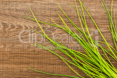 Fresh Raw Chives on brown wood