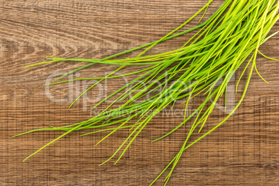 Fresh Raw Chives on brown wood