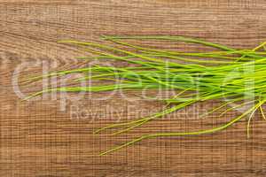 Fresh Raw Chives on brown wood