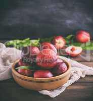 red ripe peaches nectarine in a brown wooden bowl