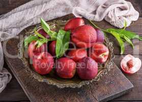 red ripe peaches nectarine in an iron plate