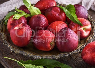 red ripe peaches nectarine in an iron plate