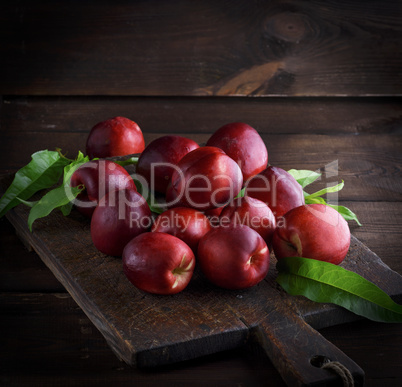 red ripe peaches nectarine on a brown wooden board