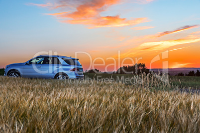 Moody sunset with cornfield and car