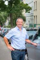 Man is standing on the street next to car