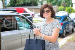 Woman next to car on the street