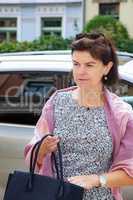 Woman next to car on the street