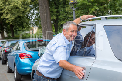 Man hugs his car in the street for joy