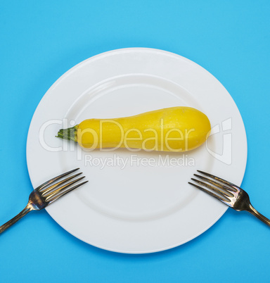 raw yellow squash in a white ceramic plate