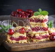 square slice of crumble pie with cherry