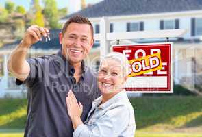 Young Adult Couple With House Keys In Front of Home and Sold For