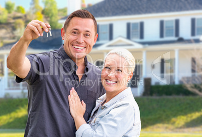 Young Adult Couple With House Keys In Front of Beautiful Home