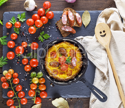 fried omelette from chicken eggs with red cherry tomatoes