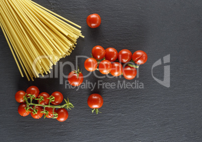 raw Italian long pasta and ripe red cherry tomatoes