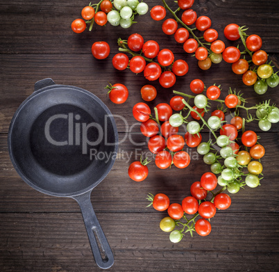 empty black cast-iron frying pan and red cherry tomatoes