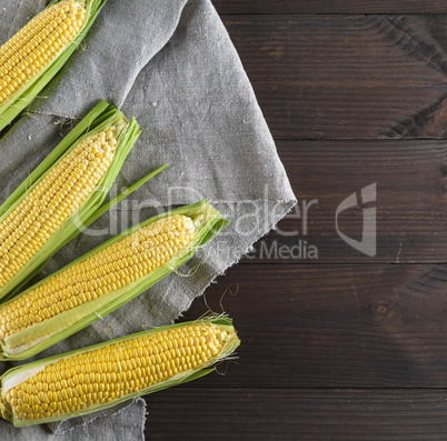 fresh ripe corn cobs on a gray linen napkin