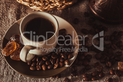 cup of coffee with beans, dark candy sugar and pot