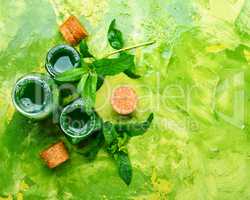 Essential mint oil with green leaves