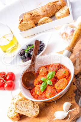 Baked mini meatballs in tomato sauce with basil