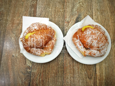 Two fresh croissants stuffed with cream