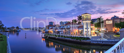 Sunset over the colorful shops of the Village on Venetian Bay