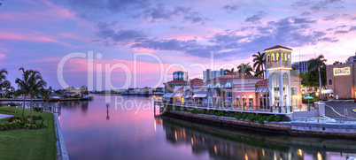 Sunset over the colorful shops of the Village on Venetian Bay