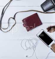 leather purse and smartphone with headphones