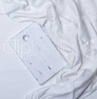 rectangular white cutting board on white textile tablecloth