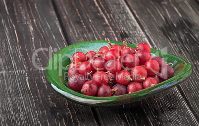 Red gooseberry in clay bowl