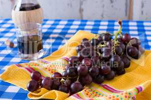 Closeup of a bunch of red grapes and a glass of red wine