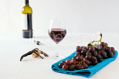 Bunch of red grapes and a glass of red wine with a wine bottle