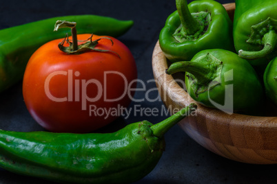 tomato and chili pepper on a dark background