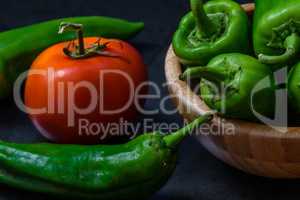 tomato and chili pepper on a dark background